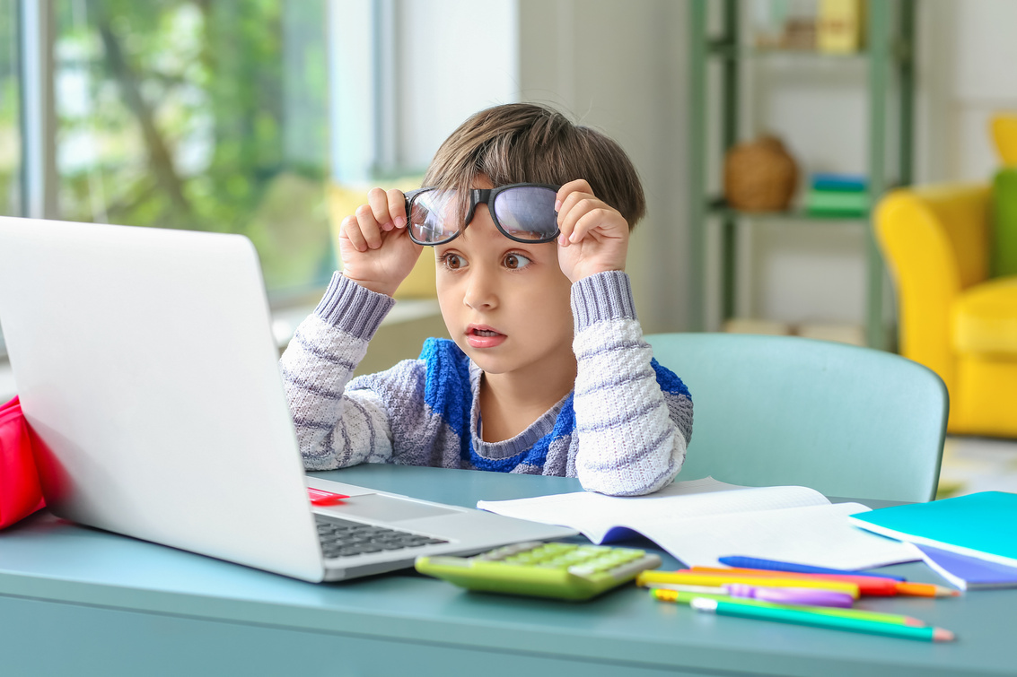 Shocked Little Boy Studying Online at Home